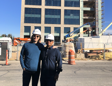two people standing in front of construction of a business office